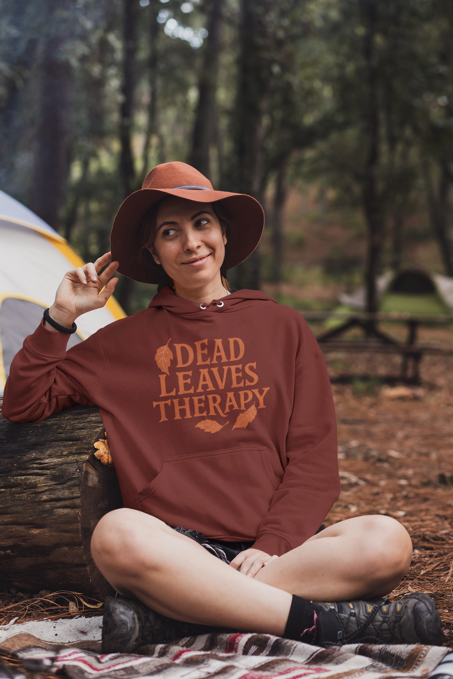Person wearing a hoodie with 'Dead Leaves Therapy' text in a forest setting