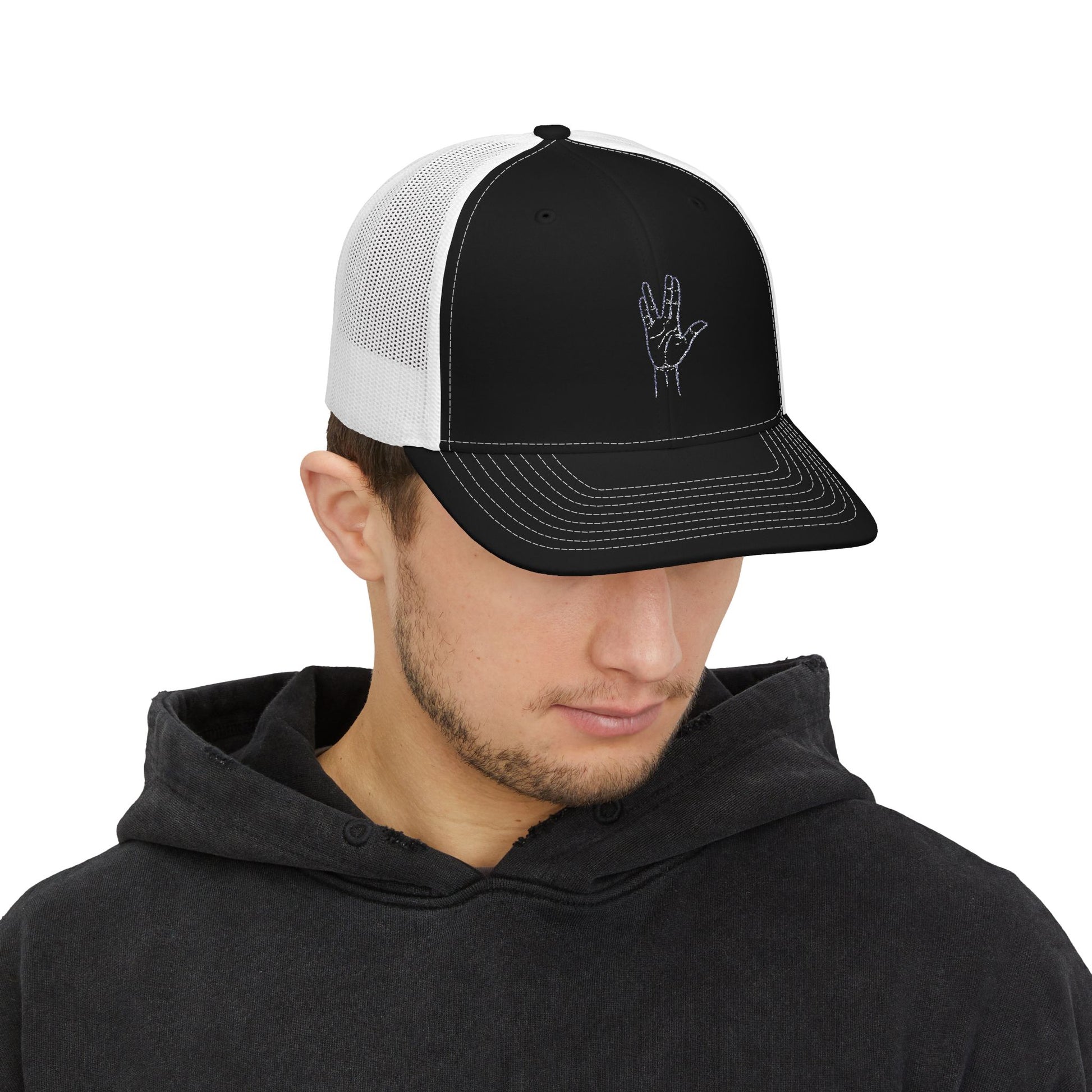 Man wearing a black and white trucker cap with a design on a white background