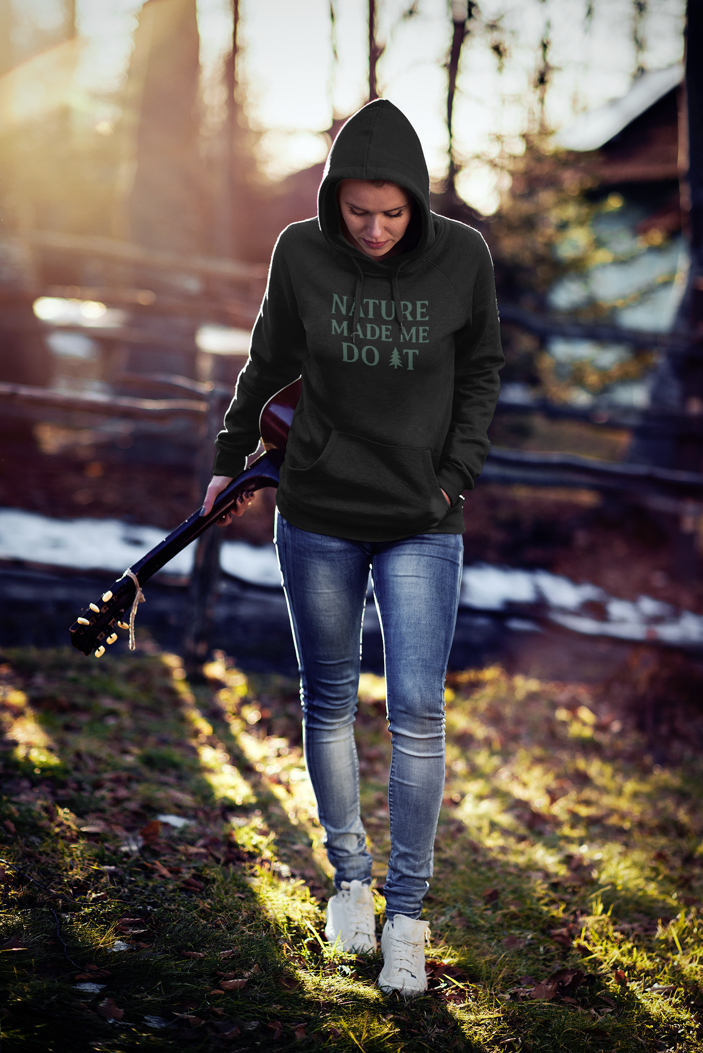Person wearing a hoodie with text walking on a path in a natural setting